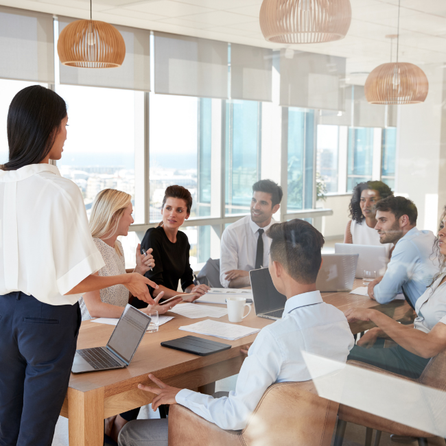 Une dirigeante présente les résultats et indicateurs de performance de l'organisation lors d'une réunion stratégique avec son équipe de direction.