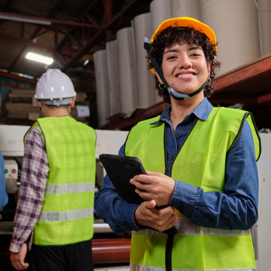 Technicienne de maintenance utilisant une tablette pour suivre une intervention sur site industriel